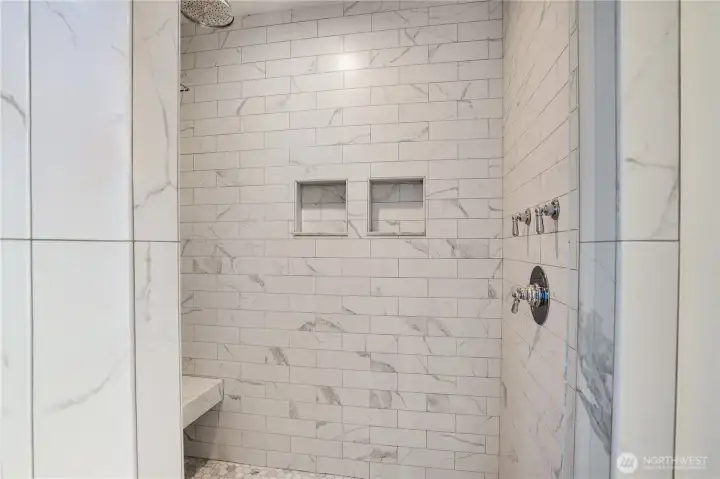Floor-to-ceiling Calacatta marble subway tile, dual built-in niches, bench seat, and Rohl fixtures including a rain head. The same marble carried through the floors and counters is fully expressed here. This shower is not a feature — it is a daily ritual.
