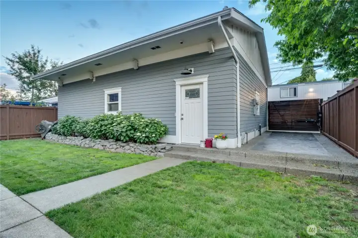 The detached garage — matching siding, painted trim, and a clean entry door. Solar panels on the south-facing roof offset approximately 50% of the home’s energy costs. Inside: 36x30 footprint, vaulted ceilings, gas heater, and storage at a scale rarely found in residential settings.