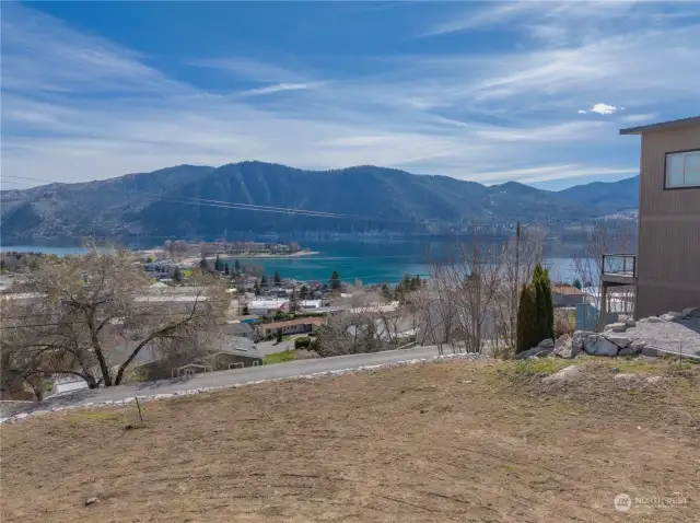 View 1 of homesite looking across road towards views of Lake Chelan and the surrounding mountains.
