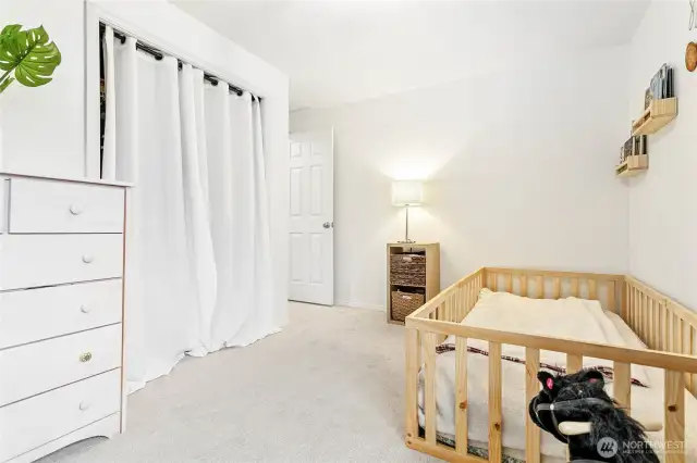 Second bedroom has  closet; the curtain softens the space.