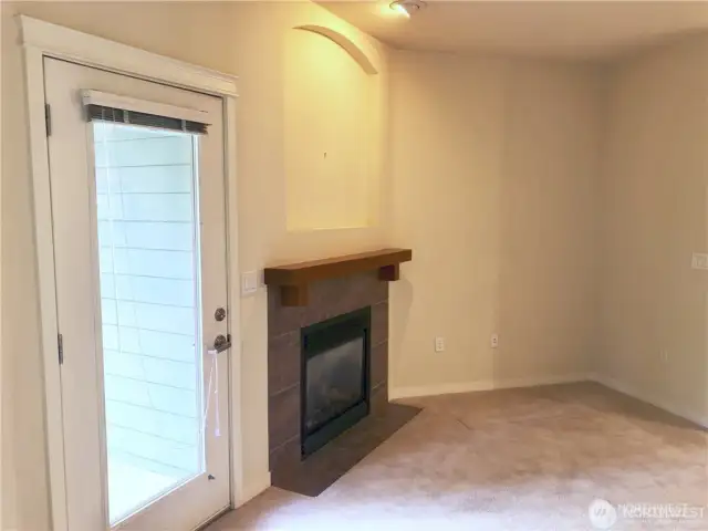 Another view of the door to the balcony and fireplace with mantle.