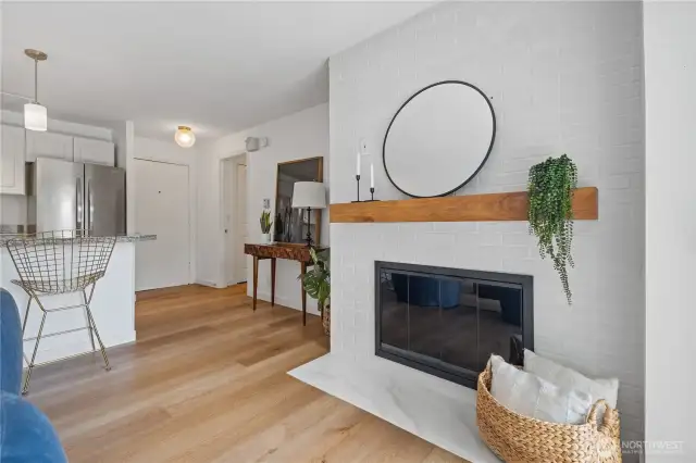 You're welcomed by the warmth of a marble-framed wood-burning fireplace that beautifully anchors the open-concept living, kitchen, and dining areas—creating a cozy and inviting space to gather and unwind.
