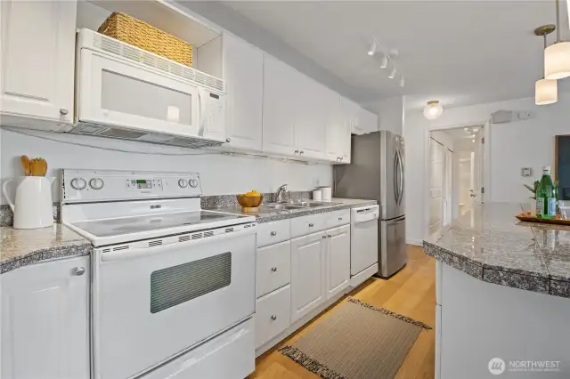 The kitchen boasts timeless white cabinetry, brand-new appliances, and a true chef’s experience—designed for both functionality and style, whether you're whipping up weeknight dinners or entertaining guests.