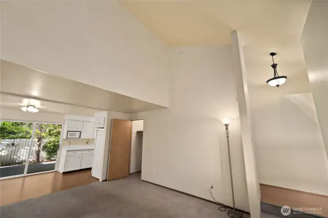 A view of the vaulted living room.  The entry is off to the right and to the left is the kitchen/dining area. Oversized storage closet at the rear of the living room.