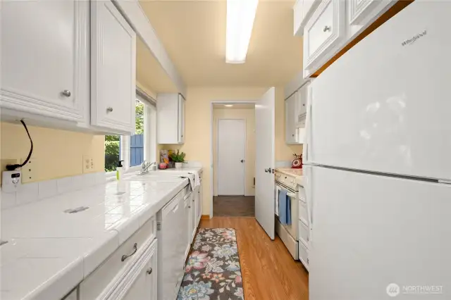 A kitchen with great counter space. The utility room is beyond the kitchen.  Access the garage or the main floor half bath from the utility room.