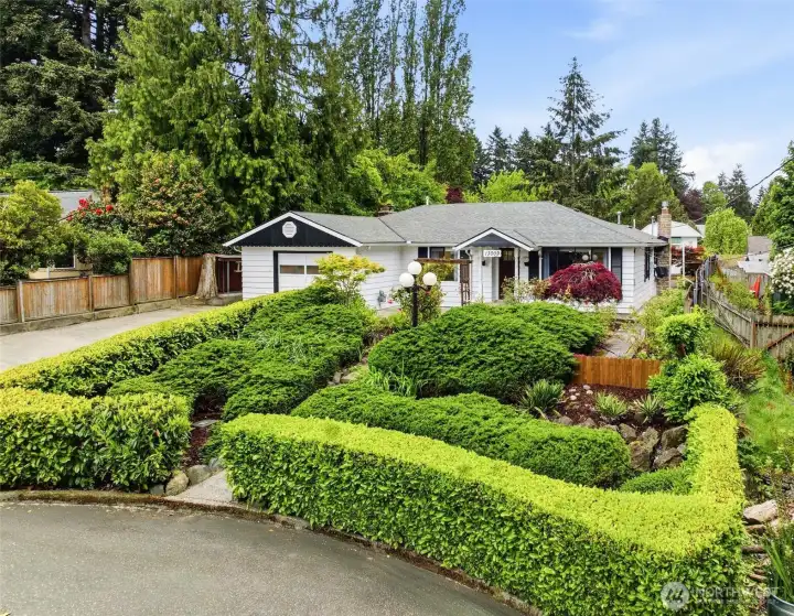 Lush landscaped gardens welcome you to this peaceful Burien home with mature plantings and exceptional curb appeal.
