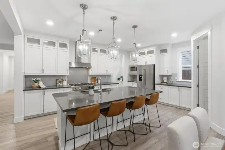 The chef’s kitchen flows seamlessly into the dining area, creating an ideal layout for gathering and entertaining.