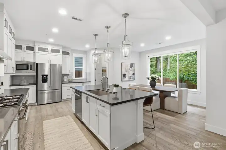 Extensive quartz countertops and a generous central island create the perfect hub for cooking, gathering, and hosting.