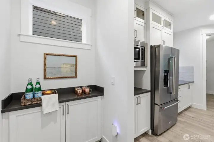 Perfectly positioned between the garage and kitchen, this built-in service area functions beautifully as a coffee bar, beverage station, or everyday drop zone.
