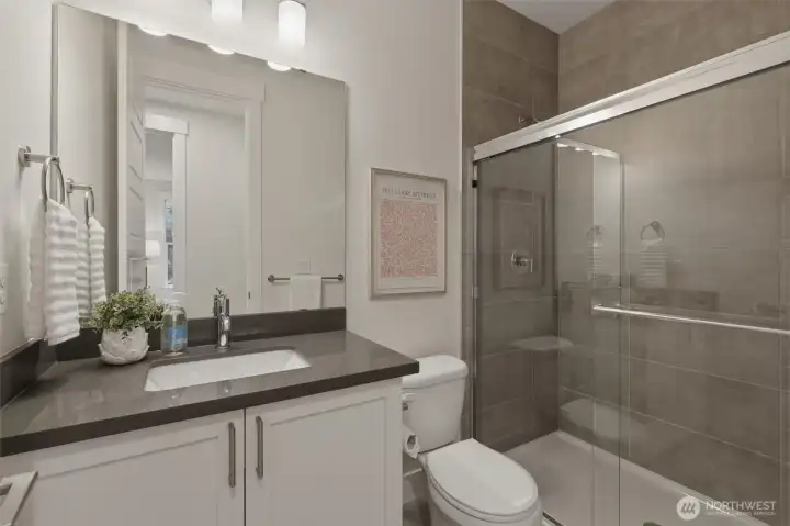 The main-floor guest bath features modern finishes and easy access from the adjacent bedroom.