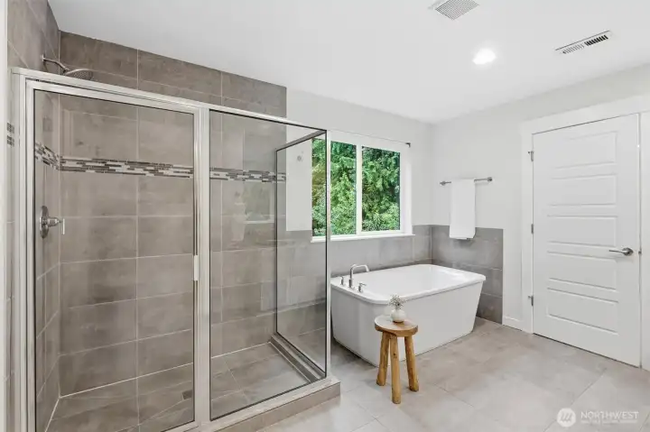 The bright ensuite pairs a deep soaking tub with a generous walk-in shower and peaceful natural light.
