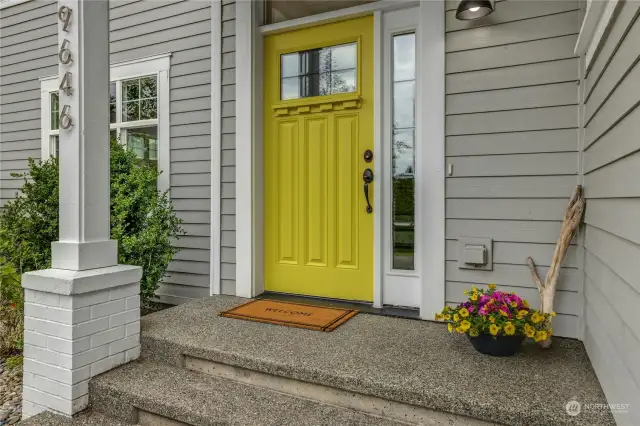 A cheery covered front porch welcomes you home and greets your guests.