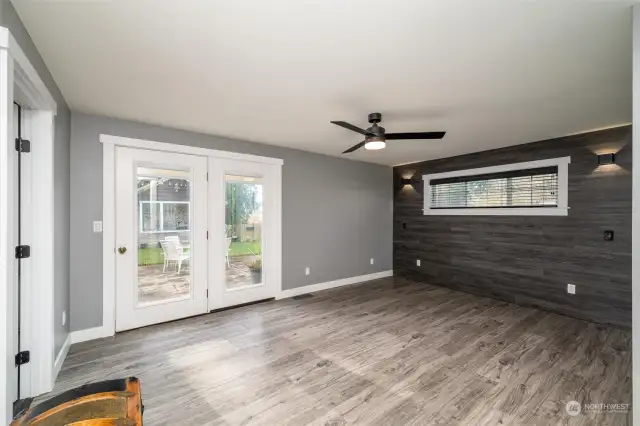 Primary bedroom with doors leading out to back patio.