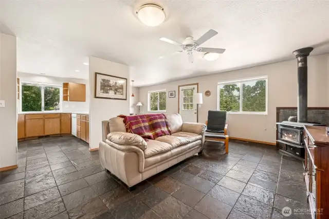 This family room serves up textured slate floors, crisp white walls, and breezy vibes courtesy of the ceiling fan. Bonus: the open line of sight into the kitchen and dining area means you can keep an eye on everything.