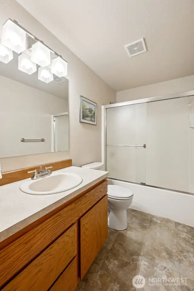 Stretch out at the long vanity, stash your stuff in classic oak cabinets, and enjoy waterproof vinyl floors that keep things easy, even when your shower concert gets loud. Sliding glass doors keep the splash zone in check.