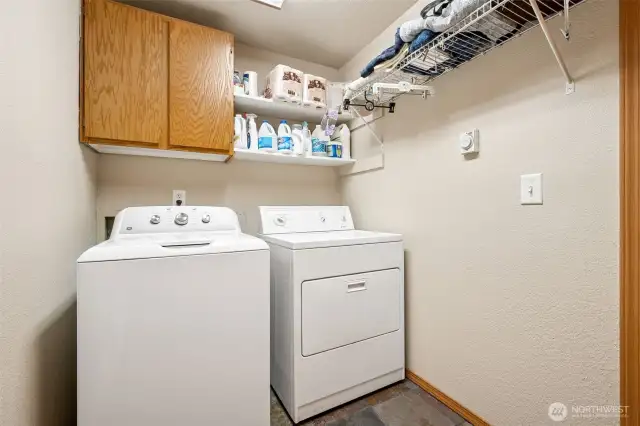 Function without the fluff. You’ve got your included washer, your dryer, slate tile underfoot that laughs in the face of muddy socks, and just enough cabinetry and shelving to keep you organized.