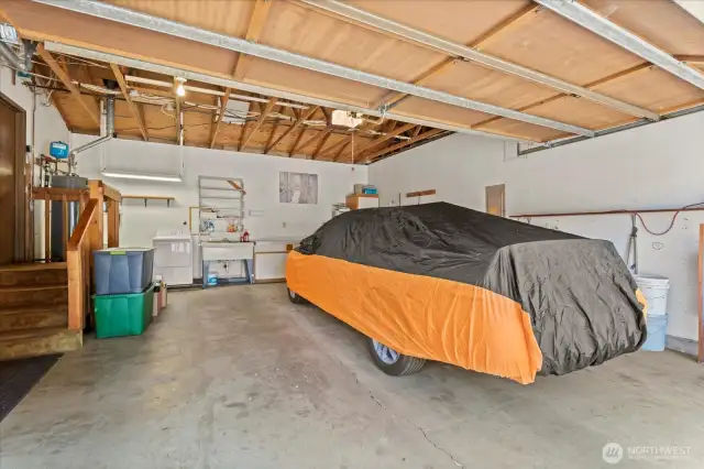 NOW, This 3rd garage is up front with main floor accessed just 4 steps from slab. oversize 2-car makes a total of 8 covered spots for your collection. Double deep utility sink and Laundry space and high open rafters makes for more spots to stash your storage