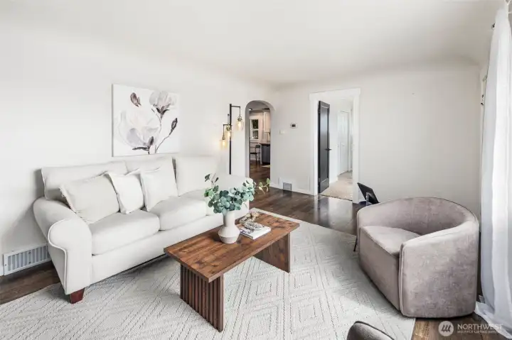 With its arched doorway, statement lighting, and neutral palette, this living room is ready for both quiet mornings and lively gatherings.
