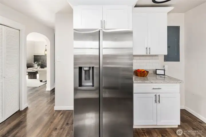 A full-size stainless fridge sits right off the living room—style, storage, and convenience all in one.