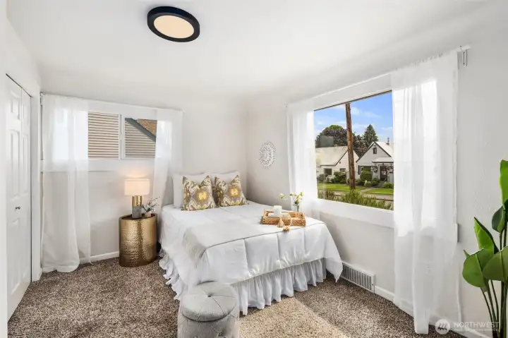 Large corner windows fill this bedroom with light, creating a bright and airy space at the front of the home.