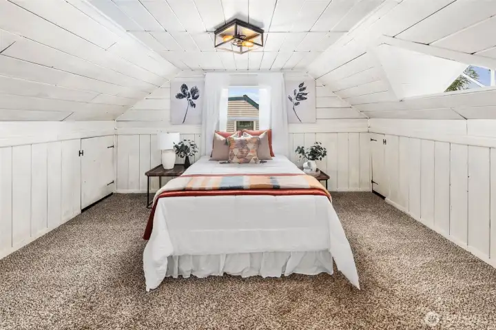 Charming upstairs bedroom with wood-paneled character, dormer windows, and plenty of natural light.