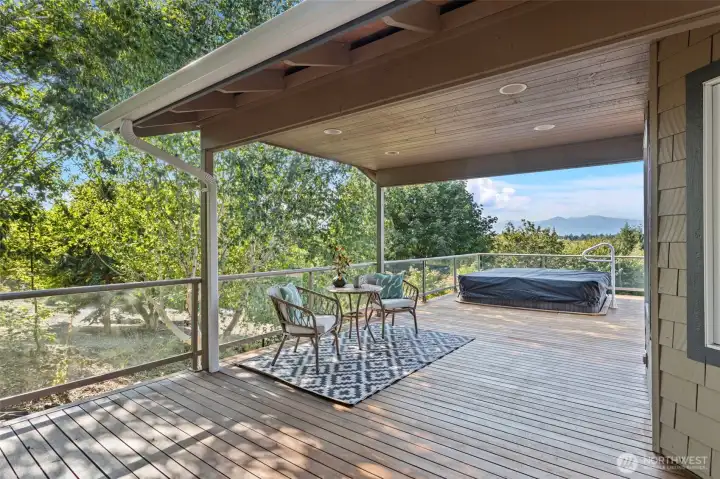 The deck, stretching the full length of the home and gracefully wrapping around the side, boasts a covered section perfect for year-round enjoyment.