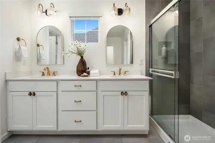 This gorgeous private bath features tiled floors, dual vanities, a linen closet, an oversized tile shower and a separate water closet.
