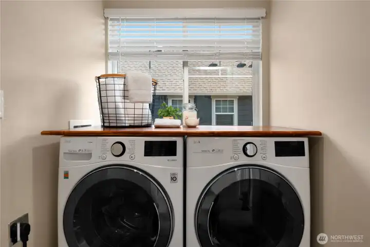 Front loading full-size washer and dryer with hardwood folding table stay with the house.