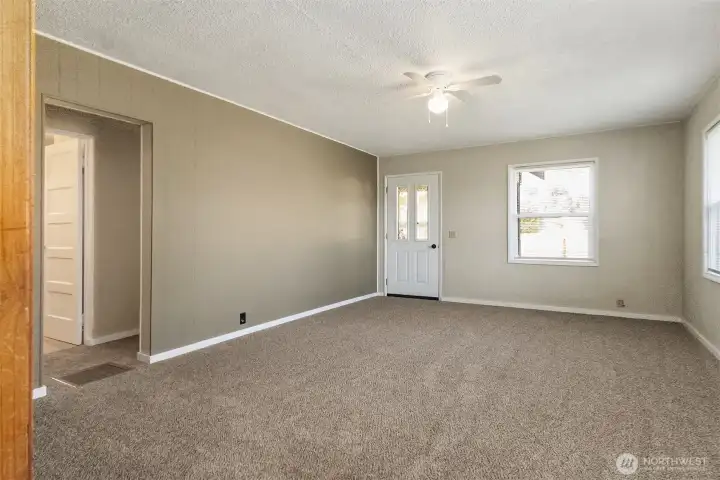 Living Room and front entry door facing East without virtual staging