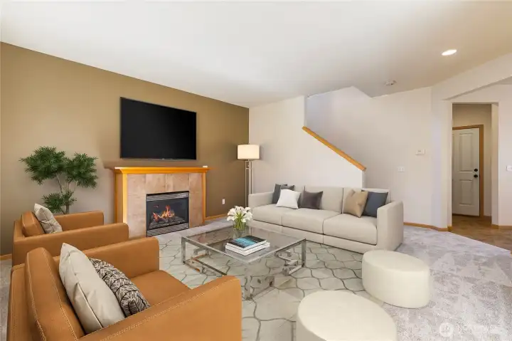 Virtually staged living area looking towards gas fireplace and stairs to upstairs