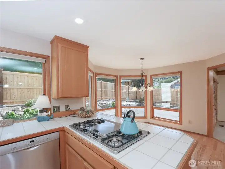 look at ALL the Windows! This Kitchen is SO Bright.. Bar features Gas Cooktop… NEW Wall Oven and Microwave
