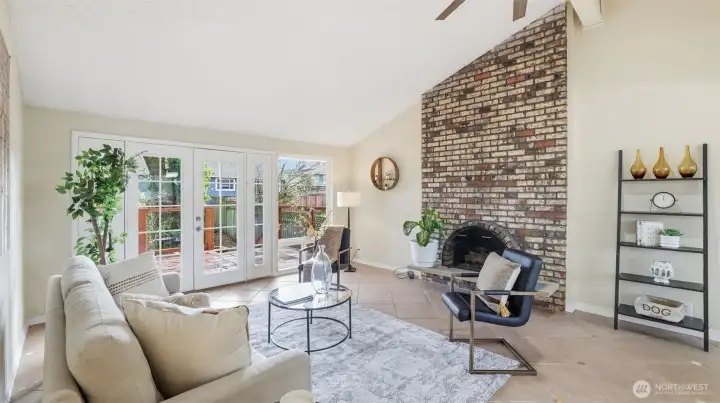 Enjoy vaulted living space with classic brick fireplace and warm natural light