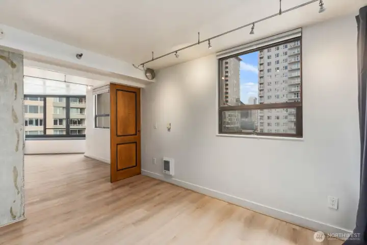 Flexible Seattle condo living space with large windows capturing nearby city views and an open layout that connects naturally to the main living area.