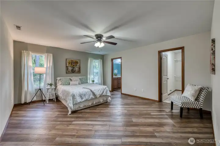 Primary suite is enormous, with newer hard surface flooring and lots of natural light.