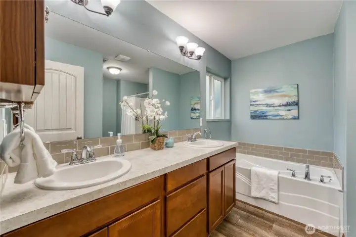 Primary bath has dual vanities and a large soaking tub.