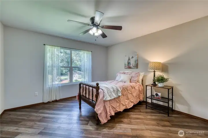 Additional bedrooms are on the opposite side of home from the primary suite.  This one has newer hard surface flooring and great natural light.
