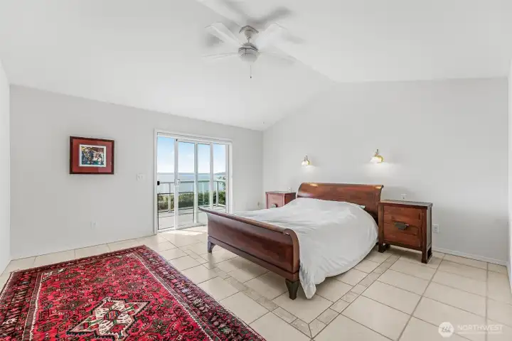 The convenient main-floor primary suite features direct deck access, dual closets, & a spacious ensuite.