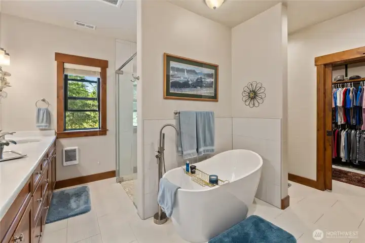 Primary bathroom suite with double vanity, walk in shower, soaking tub, and walk in closet.