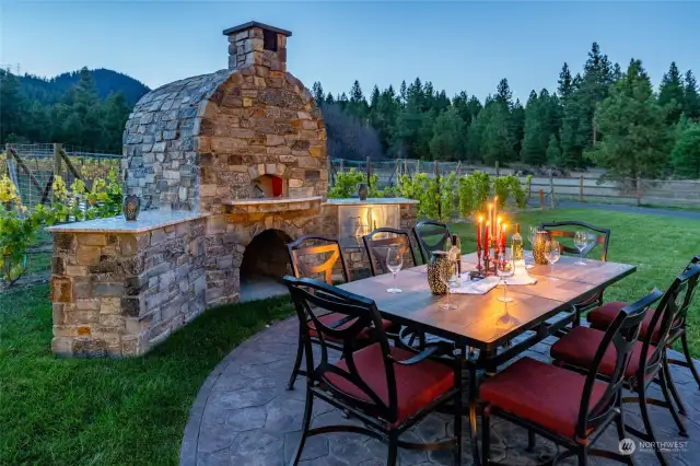 Newly built exterior entertaining area with fieldstone masonry, new Mugnaini Medio 110 pizza oven, and expansive seating area