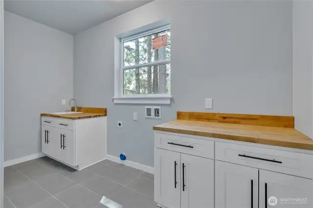 Laundry room is spacious and features butcher block counters and lots of storage,