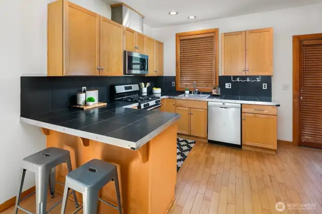 Breakfast bar for casual dining, sharing a drink with the cook or helping with culinary duties. Open kitchens allow the cook to always be part of the conversation or in this case enjoy the beautiful view out the large picture windows.