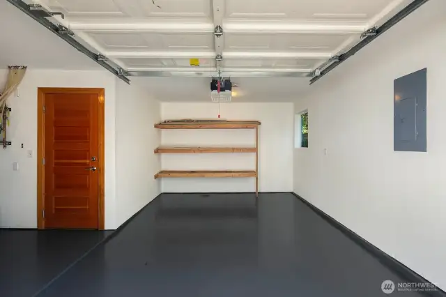 The one car garage with storage and shop space has been freshly painted