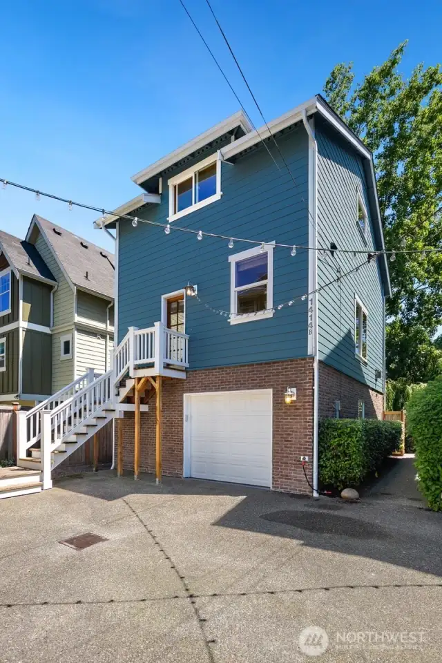 This home is one of four in its complex.  This view is of the western facing front door and garage.  Pathway on right leads to the fenced back yard.