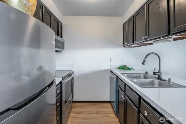 Updated kitchen with new counters, floors, appliances and freshly painted cabinets.