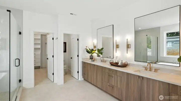 Spa-Inspired Bath:  A statement in calm sophistication, the primary bath combines timeless design with modern indulgence. Dual vanities, brass-accent lighting, and a deep soaking tub invite relaxation, while the walk-in glass shower and broad picture window deliver a true spa-day atmosphere at home.