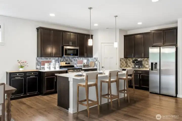 If kitchens are the heart of the home, this one has a very healthy pulse. The large quartz island offers seating for at least three and provides plenty of workspace for meal prep, entertaining or simply spreading out the newspaper and pretending you'll finish the crossword. The stainless steel gas range and newer refrigerator add modern appeal, while under-cabinet lighting creates a warm glow and makes everyday tasks easier. Thoughtful storage upgrades include pullout shelves for easy access to cookware along with a dedicated double-bin trash and recycling cabinet that keeps clutter neatly tucked away. Stylish, efficient and designed around real life, this kitchen checks a lot of boxes.