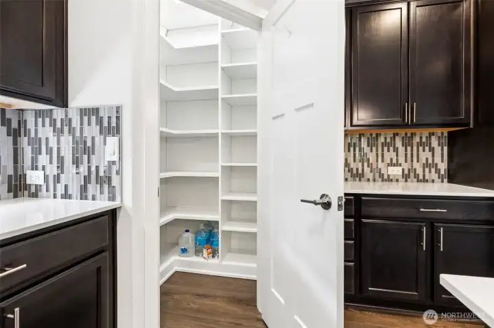 This walk-in pantry is ready for serious Costco commitment. Outfitted with a custom California Closets organization system, the space is thoughtfully designed to keep everything visible, accessible and neatly organized, whether you're stocking up on snacks, paper products or enough coffee to survive an entire Pacific Northwest winter. The shelving is generously sized and tall enough to accommodate countertop appliances, oversized serving pieces and bulk purchases without feeling cramped.