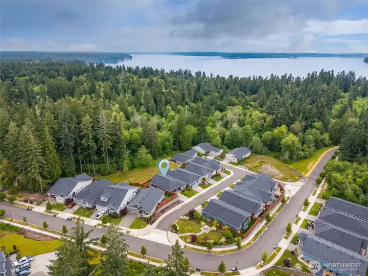 This aerial perspective really showcases why so many people fall in love with Jubilee. Quiet little Reef Lane feels tucked away from the hustle and bustle while still being remarkably close to everything you need. Protected wetlands stretch beyond the homes creating a beautiful natural backdrop, and nearby Nisqually Reach means you're close enough to enjoy refreshing saltwater breezes that become part of everyday life. Residents can access the shoreline via a groomed trail that gently winds down to the beach, making waterfront strolls surprisingly easy and enjoyable, and when it's time to run errands or meet friends for dinner, you're just minutes from all the shopping, dining and services of Hawks Prairie with quick access to I-5 for easy trips north, south or into downtown Olympia's vibrant waterfront events and arts district.