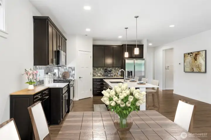 The kitchen serves as the hub of the home with easy sightlines to the dining area and living room, while the hallway beyond provides direct access to the mudroom, laundry room and garage entrance without disrupting the flow of the main living spaces. The island is both beautiful and functional, featuring an undermount sink with pull-down faucet and plenty of room for gathering, prepping and serving, and because somebody was clearly thinking ahead, the home is equipped with a tankless water heater. Whether you're hosting overnight guests, tackling a house full of holiday visitors or simply enjoying a long relaxing shower after a day at the clubhouse, hot water is one thing you won't be rationing.