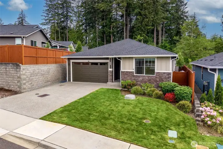 Built in 2021 and located in Olympia's sought-after Jubilee 55+ community, this home delivers the kind of curb appeal that says "I've got my life together" before you even step inside. Stacked stone accents pair beautifully with durable HardiePlank siding wrapping the entire exterior, while the brand-new insulated garage door adds a fresh modern touch with four upper windows that welcome natural light without sacrificing privacy. Even better, the HOA handles front yard maintenance and there is a sprinkler system already installed, so your lawn can stay looking fabulous while you spend your time doing literally anything else. The upgraded LiftMaster garage opener includes motion sensing technology plus an integrated camera system with app capability, making this smart garage every bit as modern as the home itself.